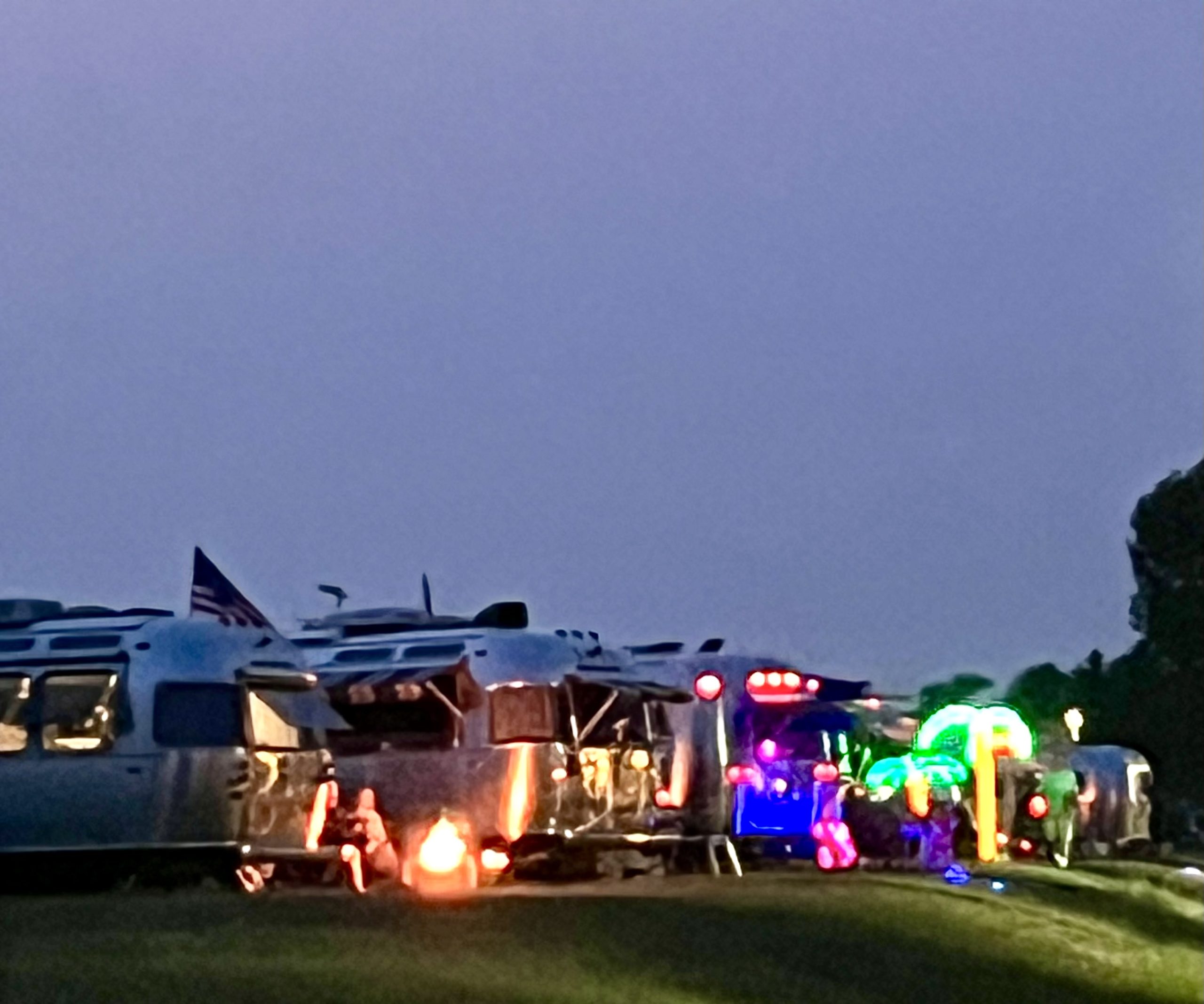 Evening scene with silver trailers and warm lights.