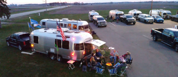 Airstream rigs and Rush Creek Distilling at dusk, lit for an evening rally.